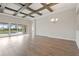 Bright living room with wood floors, beamed ceiling, and sliding glass doors to the backyard at 11622 Gleaming Ter, Venice, FL 34293