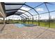 Backyard pool area featuring screened-in lanai, brick pavers, and a connected hot tub at 11622 Gleaming Ter, Venice, FL 34293