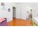 Bright bedroom features hardwood floors, closet, and doorways to additional rooms providing versatile living space at 1202 E Mohawk Ave, Tampa, FL 33604