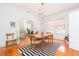 Elegant dining room with hardwood floors and stylish light fixture, seamlessly connected to the living area at 1202 E Mohawk Ave, Tampa, FL 33604