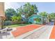 Charming turquoise home with brick driveway, lush lawn, palm trees, and a cozy landscaped front yard at 1202 E Mohawk Ave, Tampa, FL 33604