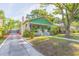 Charming green bungalow with a welcoming front porch and a well-manicured lawn and a detached garage at 1202 E Mohawk Ave, Tampa, FL 33604