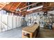 Spacious garage with exposed wooden ceiling and ample storage and workbench, offering functional workspace at 1202 E Mohawk Ave, Tampa, FL 33604