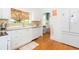 Well-lit kitchen featuring white cabinets, granite countertops, modern appliances, and hardwood floors at 1202 E Mohawk Ave, Tampa, FL 33604