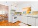 Bright kitchen with white cabinets, granite countertops, and modern appliances, adjacent to the dining room at 1202 E Mohawk Ave, Tampa, FL 33604