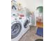 Well-equipped laundry room featuring modern washer and dryer, shelving and a view to a sun room at 1202 E Mohawk Ave, Tampa, FL 33604