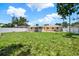 Spacious backyard enclosed by a white fence, with a well-kept lawn and a cozy patio area at 1223 Jasmine Way, Clearwater, FL 33756