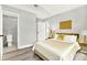 Modern bedroom featuring a gold and white color scheme, complemented by hardwood flooring and stylish lamps at 1223 Jasmine Way, Clearwater, FL 33756