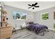 Stylishly furnished bedroom with a sleek ceiling fan, a cozy bed, and a functional desk area at 1223 Jasmine Way, Clearwater, FL 33756
