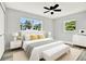 Sunlit bedroom featuring a white bed with yellow cushions and a matching bench, creating a peaceful retreat at 1223 Jasmine Way, Clearwater, FL 33756