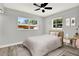 Bedroom with a light-colored bed with pink accents, complemented by a minimalist desk area at 1223 Jasmine Way, Clearwater, FL 33756