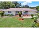 Charming single-story home featuring a well-maintained lawn and colorful, landscaped flowerbeds at 1223 Jasmine Way, Clearwater, FL 33756