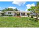 Well-manicured front yard with vibrant flowerbeds and a lush green lawn, framing the inviting home at 1223 Jasmine Way, Clearwater, FL 33756