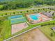 Aerial view showcasing community amenities: a pool, tennis court, and playground, designed for active lifestyles at 12351 Nouveau Ave, Spring Hill, FL 34610
