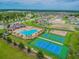 Aerial view of community amenities, including a pool, tennis court, and playground, offering diverse recreational options at 12351 Nouveau Ave, Spring Hill, FL 34610