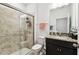 Well-lit bathroom featuring a glass-enclosed shower, granite countertop, and dark wood vanity for a modern look at 12351 Nouveau Ave, Spring Hill, FL 34610