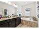 Bathroom features double vanity, soaking tub, and natural light from window at 12351 Nouveau Ave, Spring Hill, FL 34610