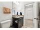 Bathroom with a dark vanity, granite countertop, and a well-lit mirror, offering style and functionality at 12351 Nouveau Ave, Spring Hill, FL 34610