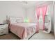 Bright bedroom with a cozy pink comforter, white furniture, and soft carpet for a comfortable retreat at 12351 Nouveau Ave, Spring Hill, FL 34610