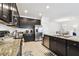 Open-concept kitchen boasts stainless steel appliances and dark cabinetry for a contemporary feel at 12351 Nouveau Ave, Spring Hill, FL 34610