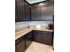 Modern kitchen featuring dark cabinets, granite countertops, and decorative backsplash at 12351 Nouveau Ave, Spring Hill, FL 34610