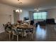 Inviting living and dining area with stylish furniture, modern lighting, and wood-look tile floors at 12351 Nouveau Ave, Spring Hill, FL 34610