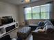 Comfortable living room with large window, sectional couch and entertainment center at 12351 Nouveau Ave, Spring Hill, FL 34610