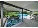 Covered backyard patio with seating around tropical rug, dining table, and view of the pool at 1305 Willow Valley Dr, Brandon, FL 33510
