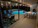 Backyard patio at night features lighting, lounge chairs, dining table, and pool at 1305 Willow Valley Dr, Brandon, FL 33510