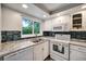 Bright kitchen featuring white cabinets, granite countertops, and stainless steel appliances at 1305 Willow Valley Dr, Brandon, FL 33510
