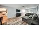 Comfortable living room with new floors, large couch, view of a kitchen and front door at 1305 Willow Valley Dr, Brandon, FL 33510