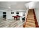 Spacious living room features a pool table, wood-look flooring, and stairs leading to the second floor at 1305 Willow Valley Dr, Brandon, FL 33510