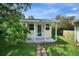 A quaint shed is surrounded by lush greenery and a brick pathway at 1305 Willow Valley Dr, Brandon, FL 33510