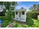 Close-up of a shed with brick trim and greenery, offering storage and a workspace at 1305 Willow Valley Dr, Brandon, FL 33510