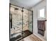 Close-up of glass shower showcasing modern tile work, shelving, and sleek black trim at 1305 Willow Valley Dr, Brandon, FL 33510
