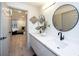 Modern bathroom boasts dual sinks, sleek white cabinets, and stylish round mirrors at 13203 Royal George Ave, Odessa, FL 33556