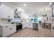 Modern, open-concept kitchen with white cabinets, stainless steel appliances, and stylish dining area at 13203 Royal George Ave, Odessa, FL 33556