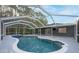 Relaxing backyard boasts a pristine pool, covered patio, and serene views at 13203 Royal George Ave, Odessa, FL 33556