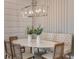 Contemporary dining area with modern lighting, stylish chairs, tufted bench, and decorative vases at 13644 Canyon Ridge Rd, Spring Hill, FL 34610