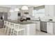 Stylish kitchen with an island and seating, white cabinets, stainless appliances, and neutral backsplash at 13644 Canyon Ridge Rd, Spring Hill, FL 34610