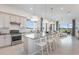 Bright and airy kitchen features an island with seating, white cabinets, and a view of the living area at 13644 Canyon Ridge Rd, Spring Hill, FL 34610