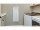 Modern laundry room featuring a washer, dryer, and white cabinetry for storage and functionality at 13644 Canyon Ridge Rd, Spring Hill, FL 34610