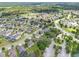 Expansive aerial view of a residential community with tree-lined streets, landscaping, and nearby lake creating a tranquil setting at 13830 Trull Way, Hudson, FL 34669