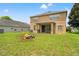 Backyard featuring a fire pit, well-maintained lawn, and a covered patio area at 13830 Trull Way, Hudson, FL 34669