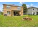 Spacious backyard with lush lawn, fire pit, covered patio, and inviting outdoor space at 13830 Trull Way, Hudson, FL 34669