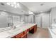 Spacious bathroom featuring double sinks, a tub, and a glass-enclosed shower at 13830 Trull Way, Hudson, FL 34669