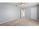 Bedroom featuring neutral carpet, light blue walls, ceiling fan and two doors at 13830 Trull Way, Hudson, FL 34669