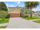 Two-story home with a two-car garage, well-maintained landscaping and palm trees at 13830 Trull Way, Hudson, FL 34669