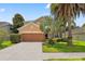 Two-story home with a two-car garage, well-maintained landscaping and palm trees at 13830 Trull Way, Hudson, FL 34669