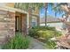 Front entrance featuring stone accents, well-maintained landscaping, and a modern light fixture at 13830 Trull Way, Hudson, FL 34669